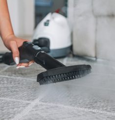 Woman cleaning carpet with a steam cleaner